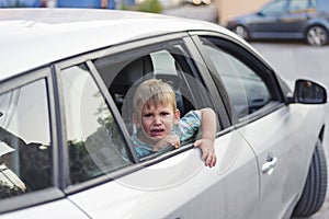 Child separated from one parent leaving in a car, sad and crying