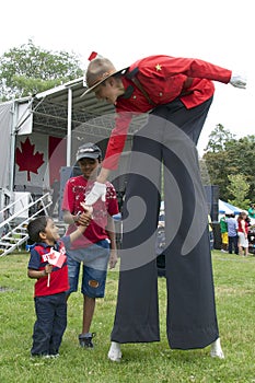 Toronto, Ontario / Canada - July 01, 2013: Child shack hand with a Canadian Mountie in the Canada Day parade