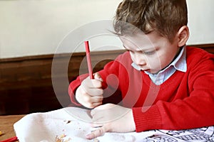 Child sharpens pencil