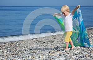 Child with shawl goes on pebble beach