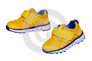 Child shoe fashion. Close-up of a pair of yellow blue child sneaker or sport shoes isolated on a white background. Elegant and