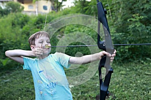 Child shooting bow in park