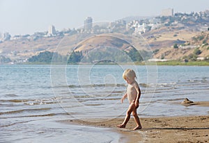 Child on the shore of lake Kinneret in the morning