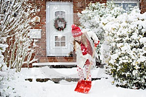 Child shoveling winter snow. Kids clear driveway