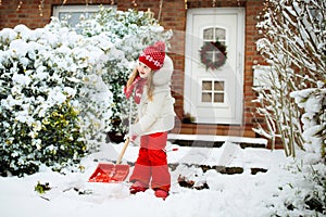 Child shoveling winter snow. Kids clear driveway