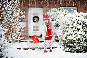 Child shoveling winter snow. Kids clear driveway.