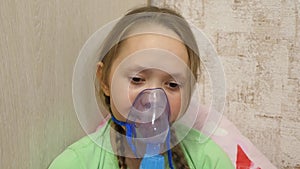 The child is sick and breathes through an inhaler. close-up. little girl is treated with an inhalation mask on her face