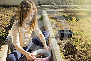 Child sieving soil for gardening