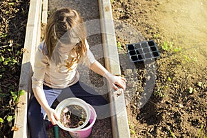 Child sieving soil for gardening