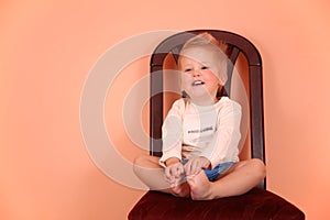 Child sit on chair in pink room