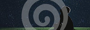 A child sit on the grass at night and look at the christmas night sky