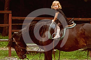 Child sit in rider saddle on animal back