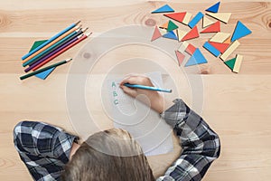 child sits doing lessons at desk