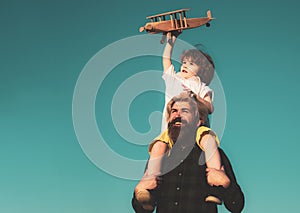 Child sits on the shoulders of his father. Kid playing imagination dream flying airplane, children& x27;s day concept