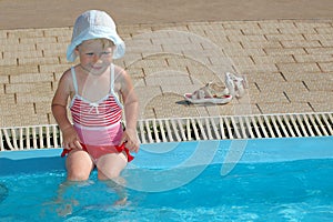 Child sits at swimming pool