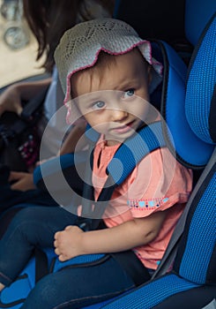 Child sitting in a Car Safety Seat looking at camera