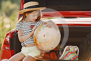 Child sitting in a car trunk