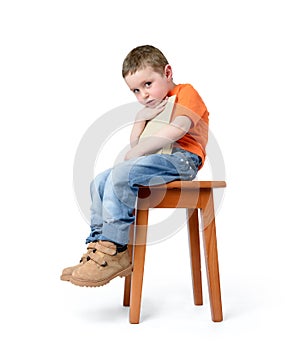 Child sitting on a chair with a book, on white background