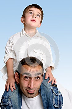Child sitting on father's shoulders
