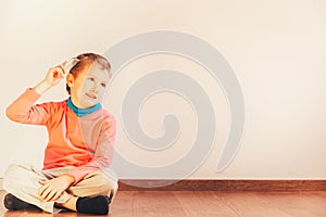 Child sitting on the floor of his house looking handsome while he only combs his hair, concept of independent and autonomous child