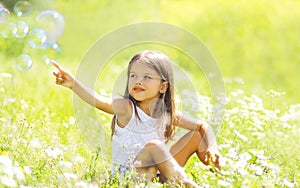 Child sitting on the grass in summer field