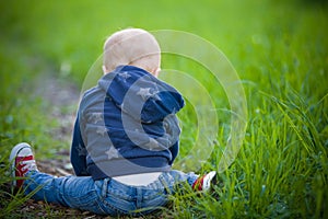 Child sitting on the green grass
