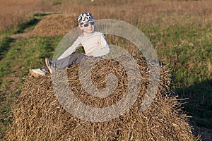Child sitting on a haystack