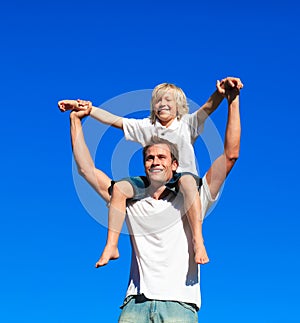 Child sitting on his father's shoulders