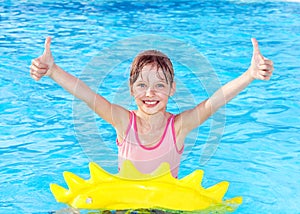 Child sitting on inflatable ring thumb up.