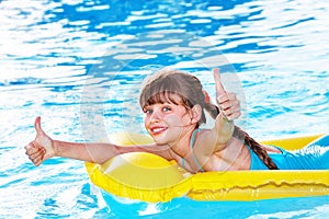 Child sitting on inflatable ring thumb up.