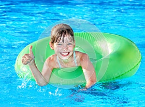 Child sitting on inflatable ring thumb up.