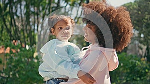 Child sitting mom arms enjoying weekend walk at park close up. Family strolling