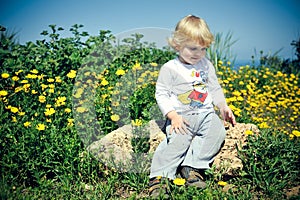 Child sitting on a rock