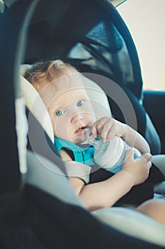 The child is sitting in a child seat in the car. photo