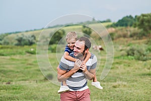 Child sitting on the shoulders of his father.