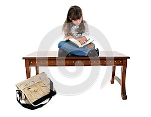 Child Sitting on Table Reading Book