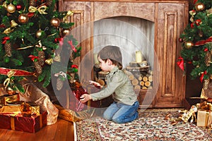 Child sitting under the Christmas tree with gifts
