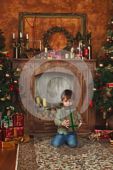 Child sitting under the Christmas tree with gifts