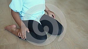 child sitting W posture on the floor .