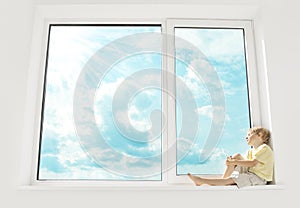 Child sitting on window, enjoying sunshine