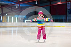 Child skating on indoor ice rink. Kids skate