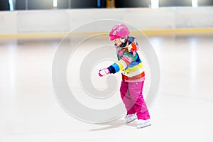 Child skating on indoor ice rink. Kids skate