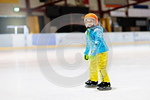 Child skating on indoor ice rink. Kids skate