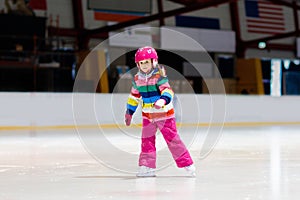 Child skating on indoor ice rink. Kids skate