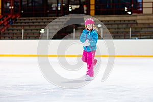 Child skating on indoor ice rink. Kids skate