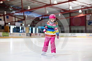 Child skating on indoor ice rink. Kids skate