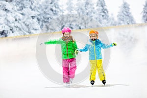 Child skating on outdoor ice rink. Kids skate