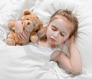 Child sleeping with a cute teddy bear