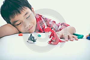 Child sleeping with his works from clay, on white. Strengthen th