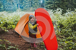 Child with sleeping pad family camping tent gear travel adventure vacations